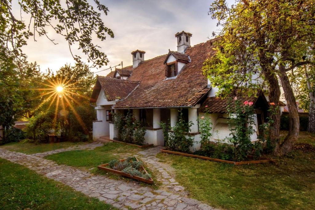 Count Kálnoky's Transylvanian Guesthouses في Micloşoara: منزل قديم تشرق عليه الشمس