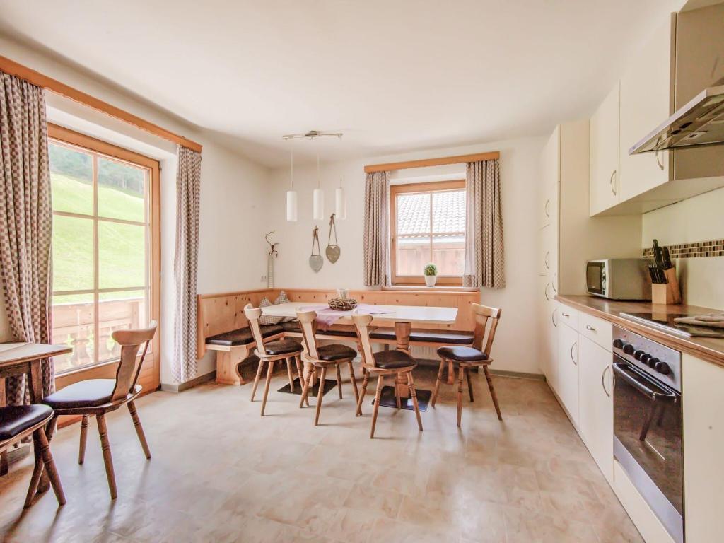 cocina y comedor con mesa y sillas en Attractive apartment in Hainzenberg with ski room, en Hainzenberg