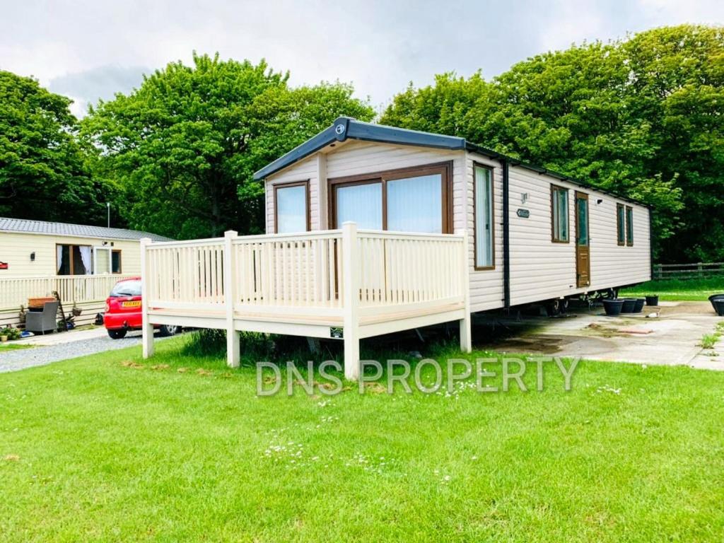 a tiny house with a porch and a yard at LUXURY CARAVAN 10 mins TO BEACH in Hull