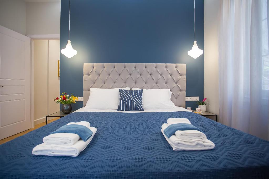 um quarto com uma cama azul com toalhas em The Sway Apartment- Luxury Loft in Corfu Town em Corfu Town