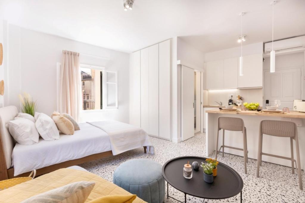 una camera da letto con un letto e una cucina con un tavolo di Little Bright Studio · Corfu Old Town a Città di Corfù
