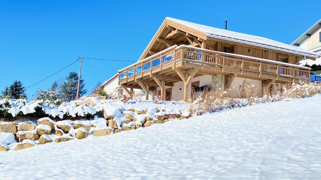 a log home in the snow with snow covered ground at Chalet Horizon 180 4 étoiles Sauna in Gérardmer