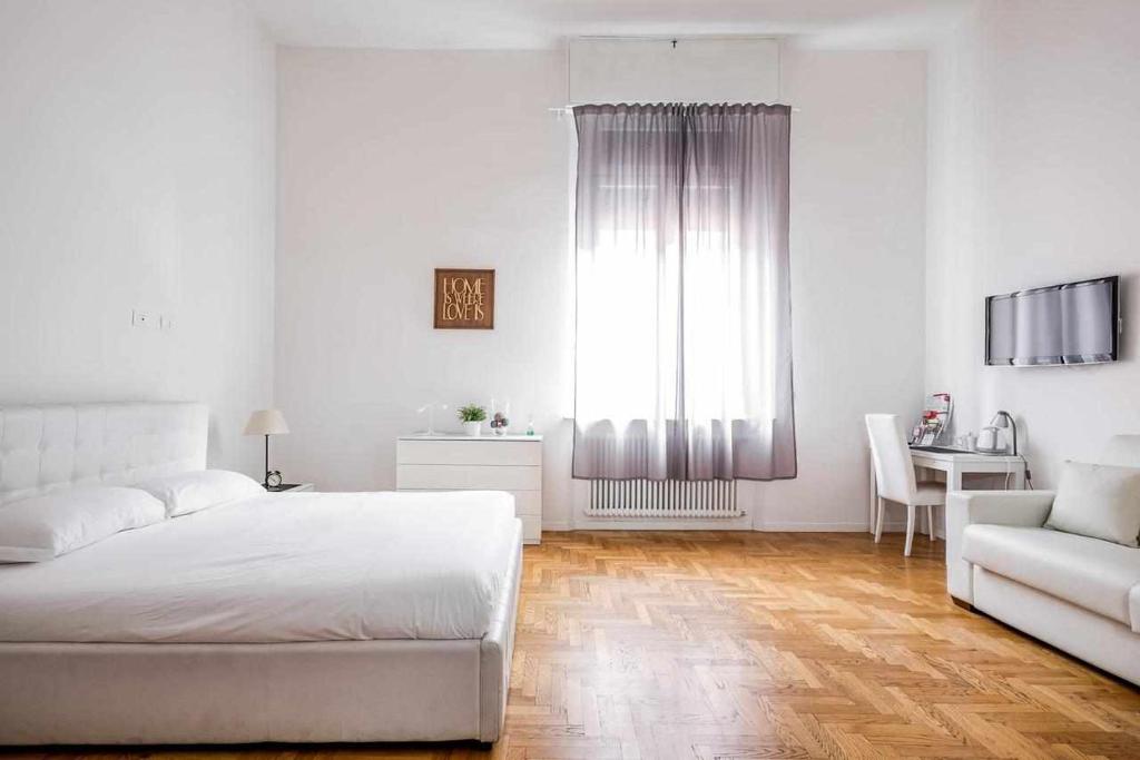 ボローニャにあるCavalieri's Grandの白いベッドルーム(ベッド1台、椅子、テーブル付)