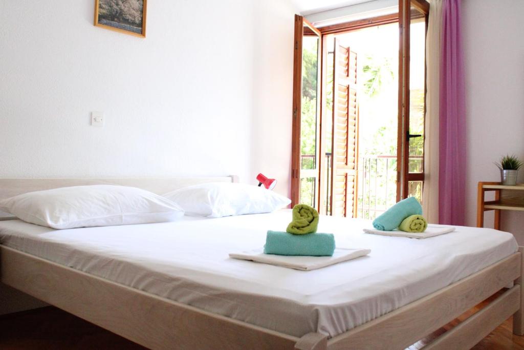 uma cama com toalhas em cima com uma janela em Apartments Slaven em Podgora