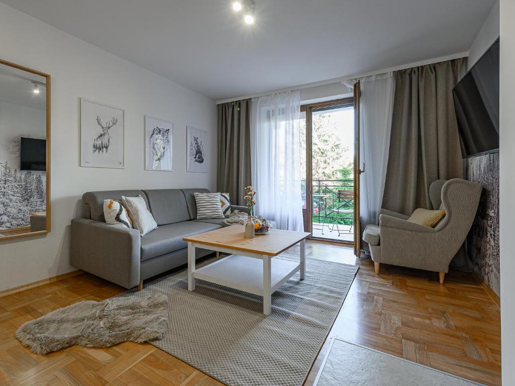 sala de estar con sofá y mesa en VisitZakopane - Rocky Apartment, en Zakopane