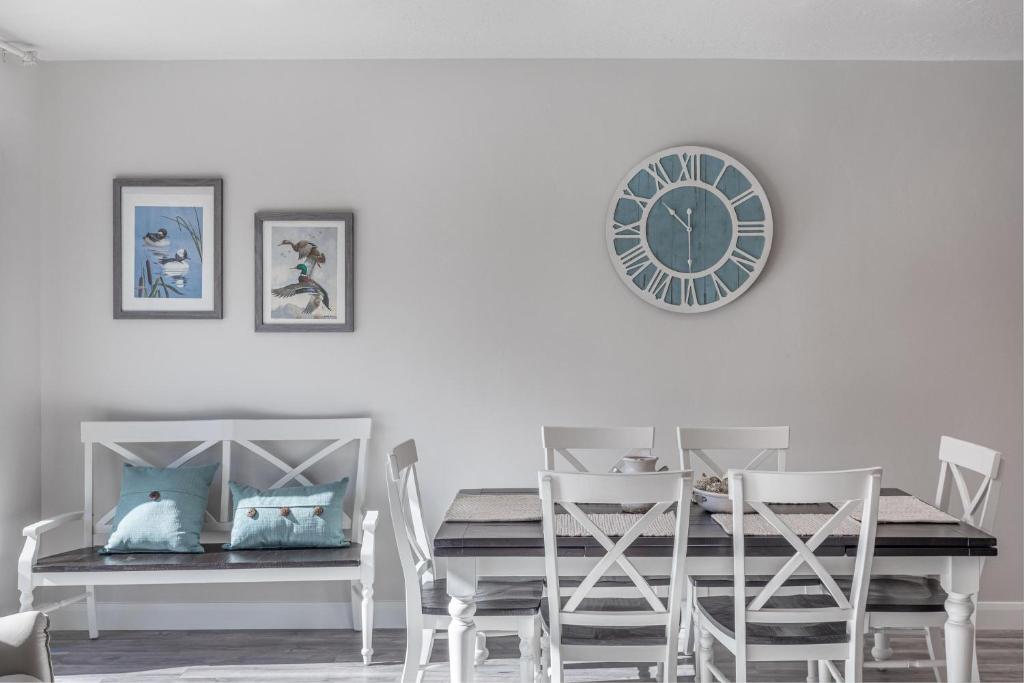 une salle à manger avec une table et une horloge au mur dans l'établissement Red Cliff Farmhouse, à Saint George