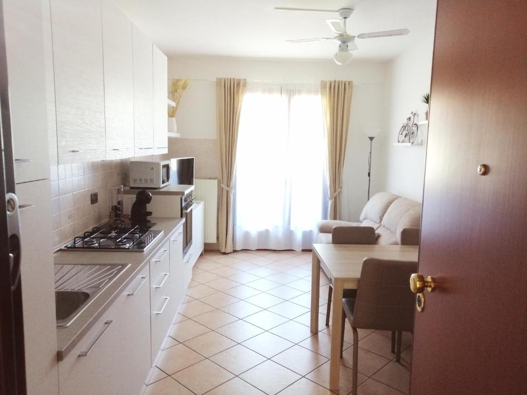 a kitchen with white cabinets and a table and a kitchen with a stove at Casa Roberto in Susegana