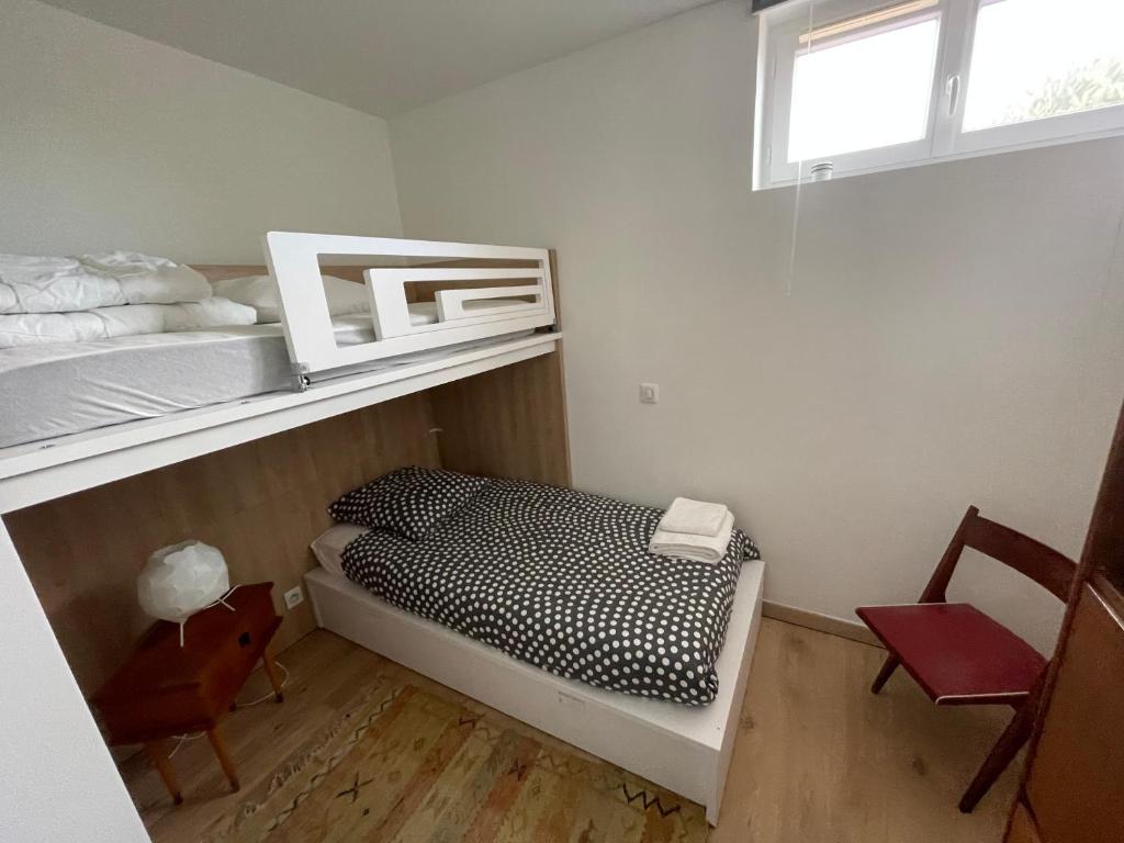 a small bedroom with a bunk bed and a chair at Villa Julie in Biarritz