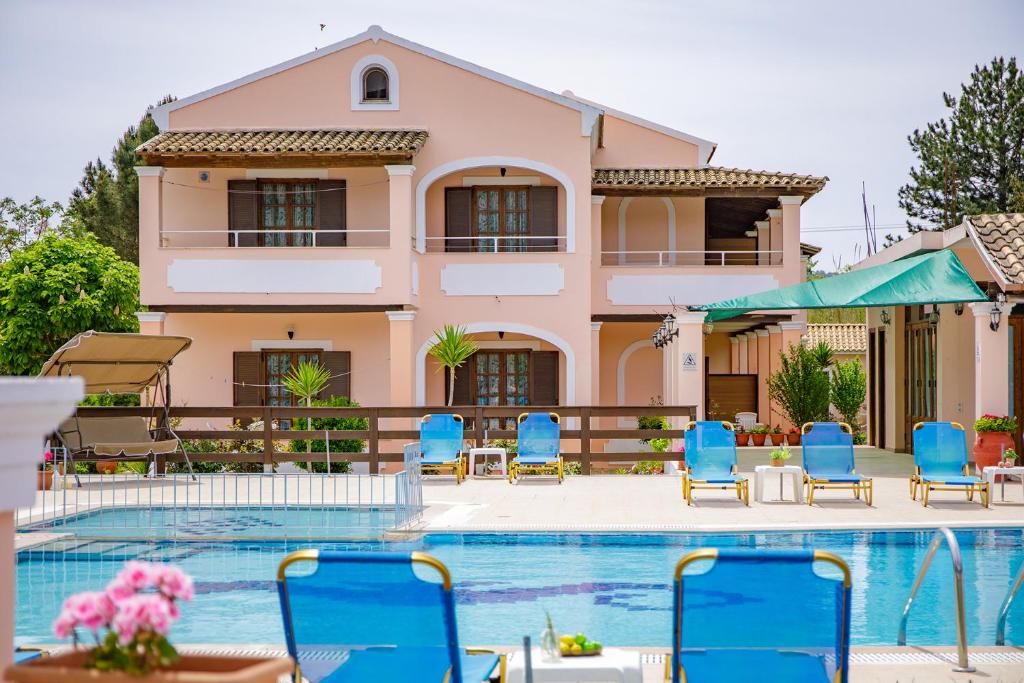 a villa with a swimming pool and blue chairs at Nikos Pool Apartments - Ground Floor in Sidari