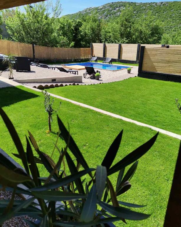 a backyard with a swimming pool and grass at Casa Amor in Križišće