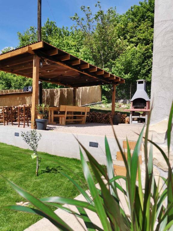 a wooden pergola with a grill in a yard at Casa Amor in Križišće