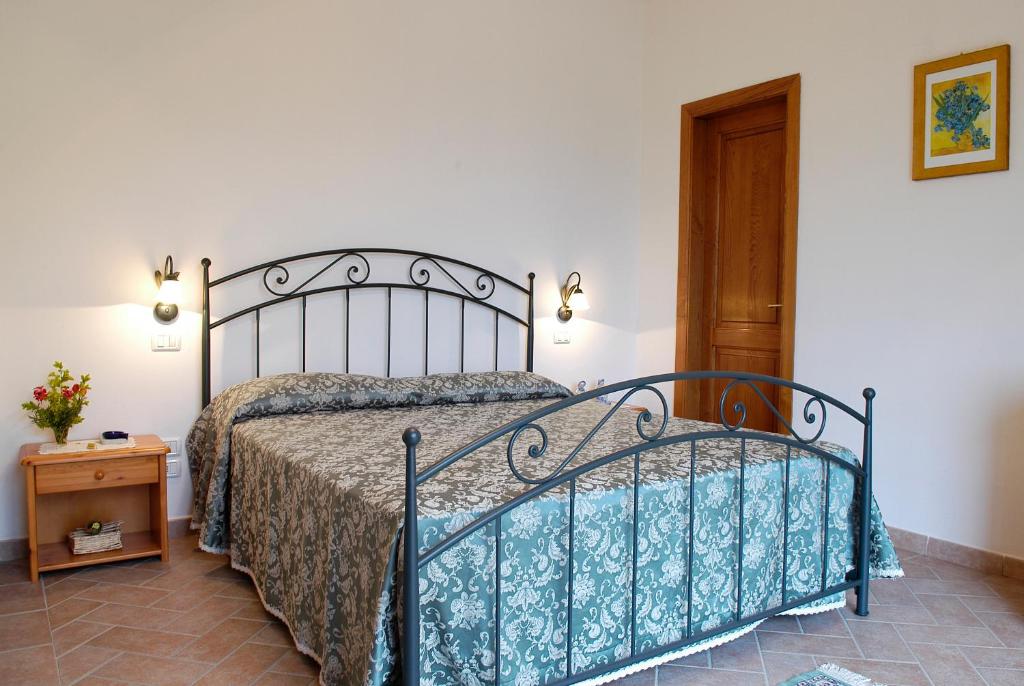 sypialnia z łóżkiem i drewnianymi drzwiami w obiekcie AGRITURISMO IL PINO - APPARTAMENTO QUERCE w mieście Gambassi Terme