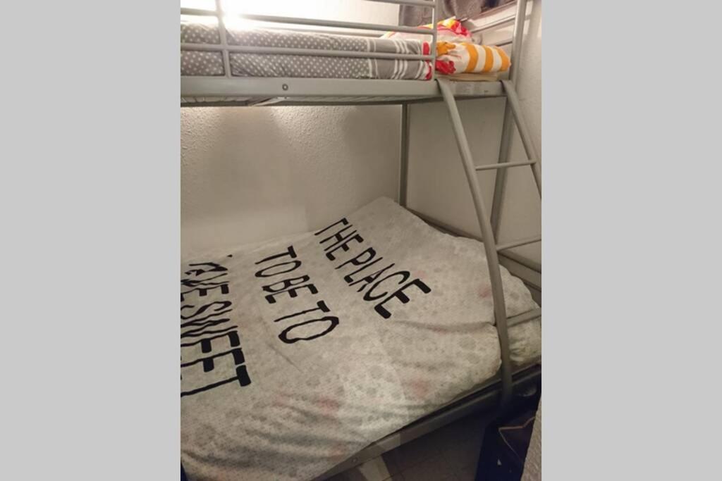 ein Kissen mit Schreiben auf einem Regal in der Unterkunft Grand studio au Grau-du-Roi proche Seaquarium et plage in Le Grau-du-Roi