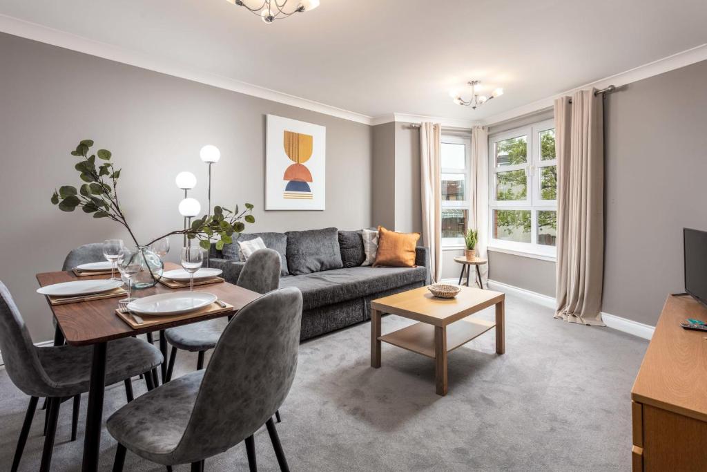 a living room with a couch and a table at Elms Way No33 – Donnini Apartments in Ayr