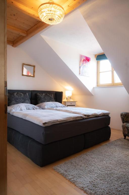 sypialnia z dużym łóżkiem na poddaszu w obiekcie Idyllische Designer-Apartments am Bio-Bauernhof in SalzburgerSeenland Schmiding 10 w mieście Seekirchen am Wallersee