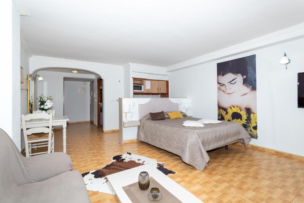 a bedroom with a bed and a living room at Unique Hotel Apartments in Torrevieja