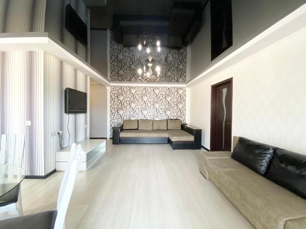 a living room with a couch and a chandelier at New apartment Lux in Most City area in Dnipro