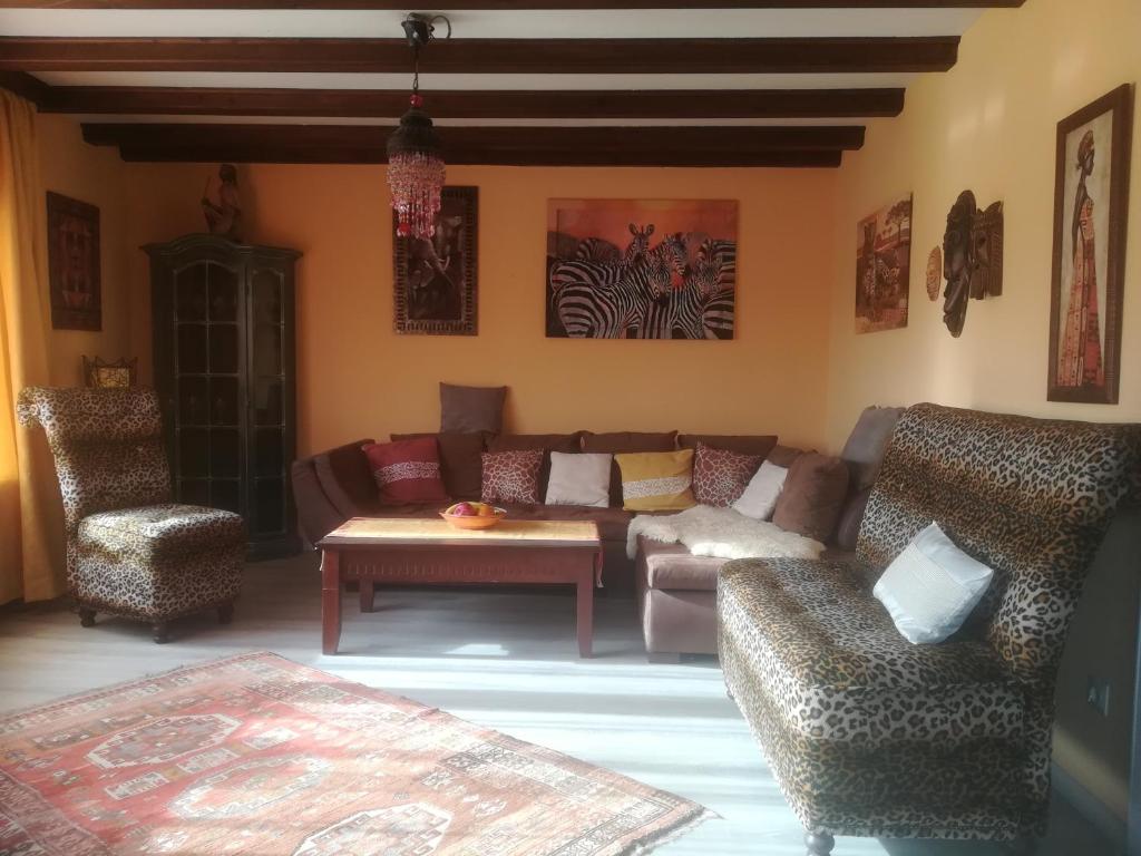 a living room with a couch and two chairs at Ferienhaus Safari in Sasbach am Kaiserstuhl