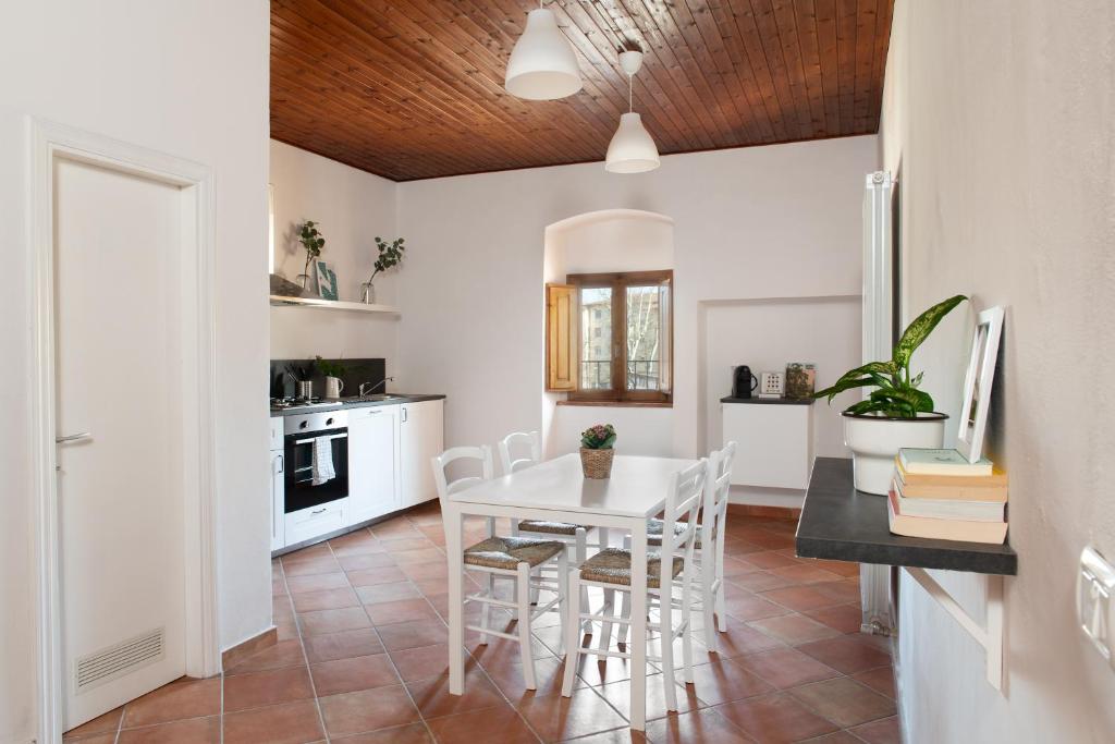 una cucina e una sala da pranzo con tavolo e sedie bianchi di Borgo Hospitality a San Piero a Sieve