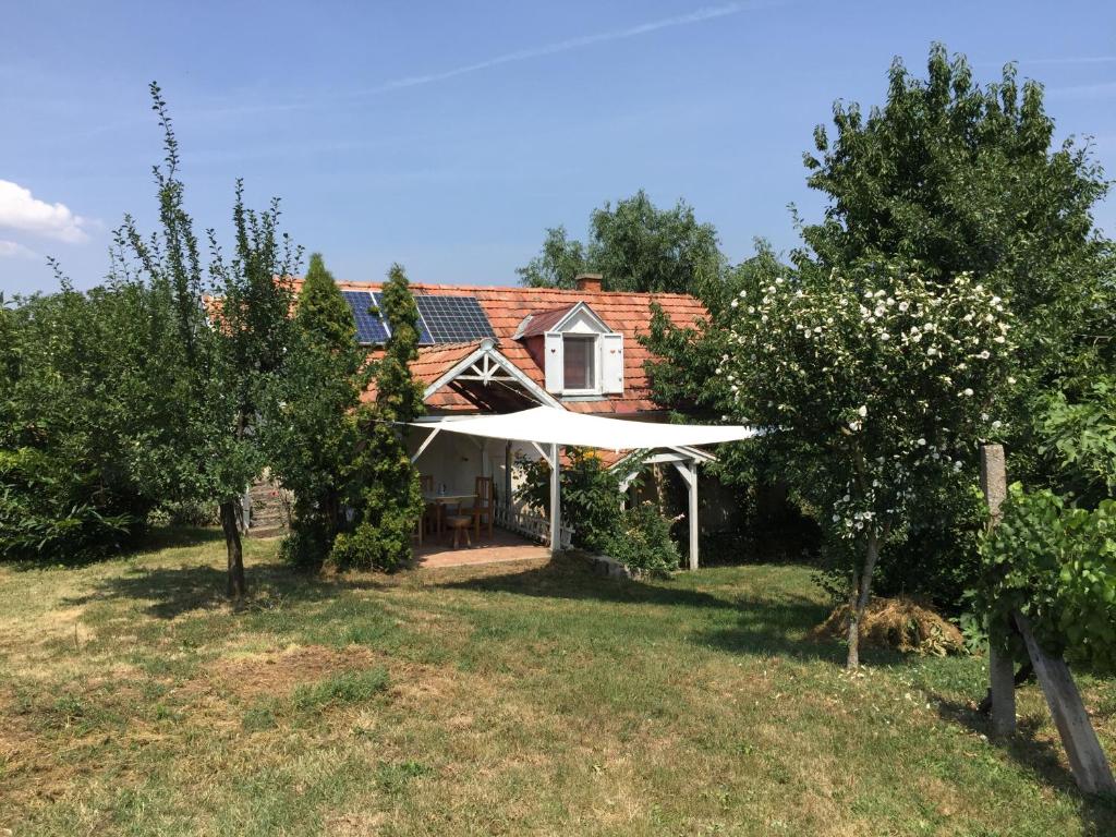 a house with a white canopy in a yard at Csobánc Szerelem-Nemzeti Park-Önalló Ház in Gyulakeszi