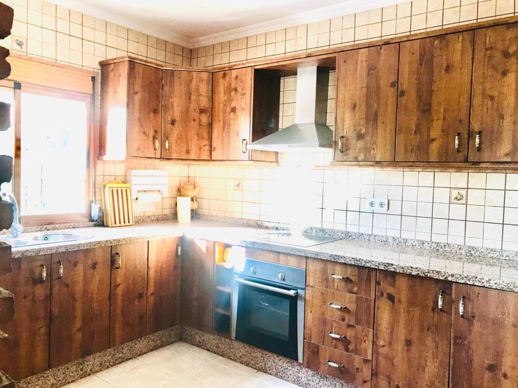 een keuken met houten kasten en een fornuis bij Casa África in Canillas de Albaida