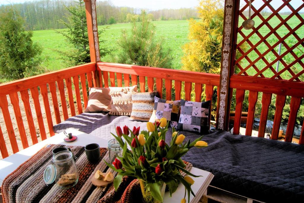 un balcón con una mesa con un jarrón de flores en Łosiowate Gospodarstwo Agroturystyczne, en Rybaki