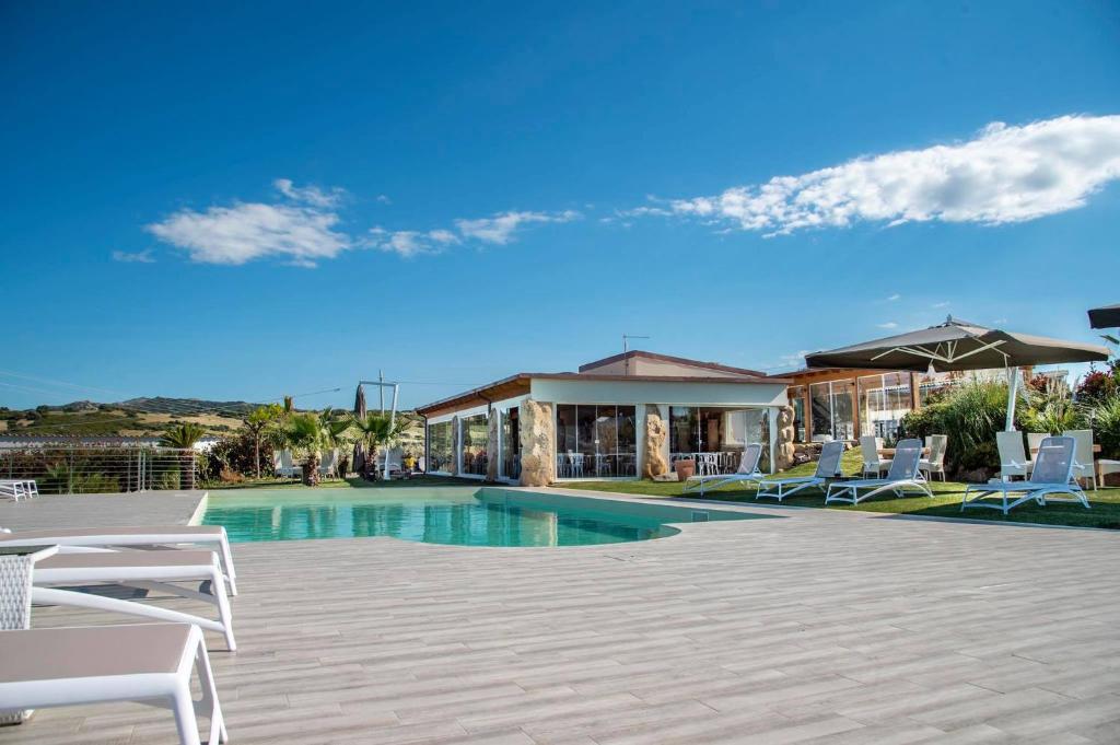 Hotel Botanic Golf SaCuba في أولبيا: مسبح مع كراسي ومظلات