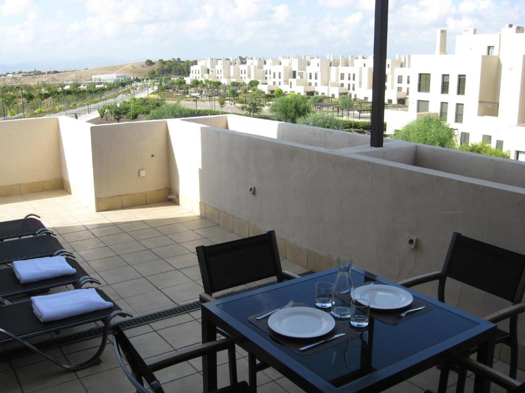 een tafel en stoelen op een balkon met uitzicht bij First Floor Non Smoking Air Conditioned 4 Person Luxury Golf Apartment in Corvera