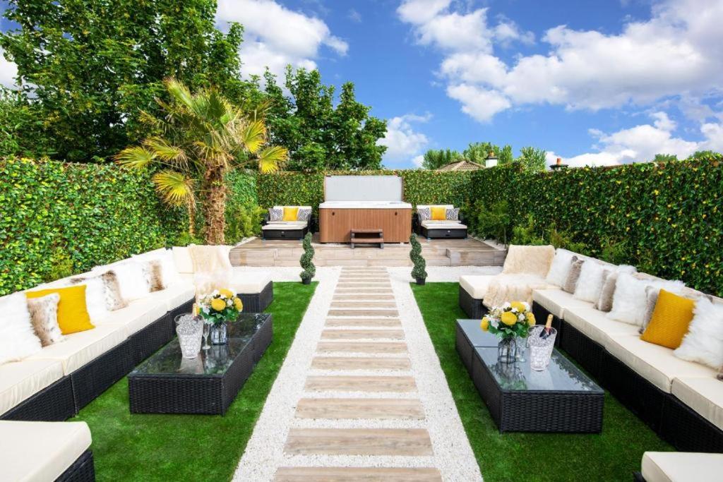 un giardino con divani bianchi e un tavolo con fiori di Luxury Cottage - City Center - Large Garden with Hot Tub -7 Bedrooms-4 Bathrooms a Galway