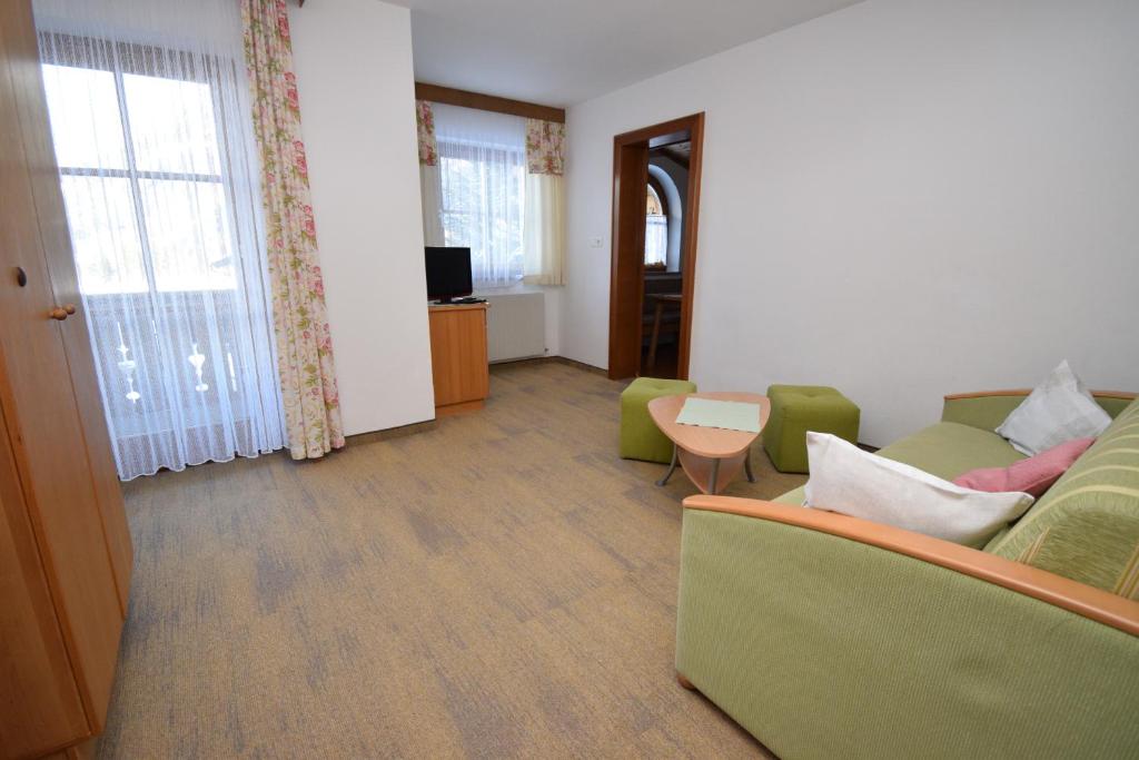 salon z kanapą i stołem w obiekcie Landhaus Bichlbach w mieście Bichlbach
