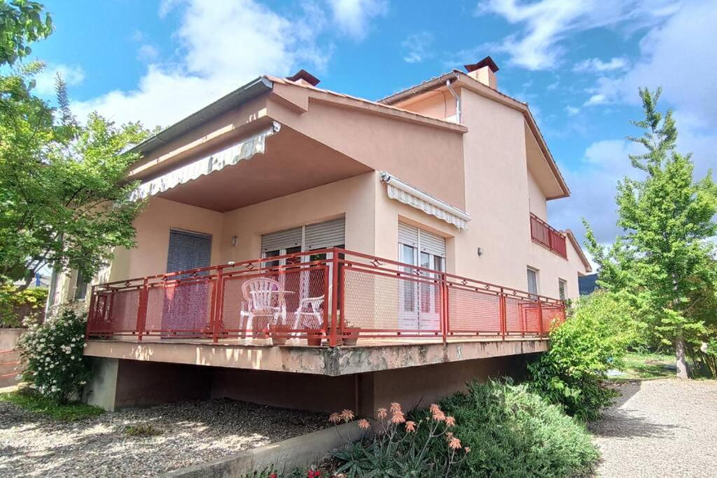 a house with a red balcony in front of it at Ca la Mercè - Agradable casa en Amer in Amer