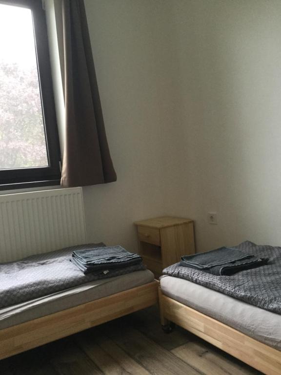 two beds in a room with a window at Gólyafészek in Abádszalók