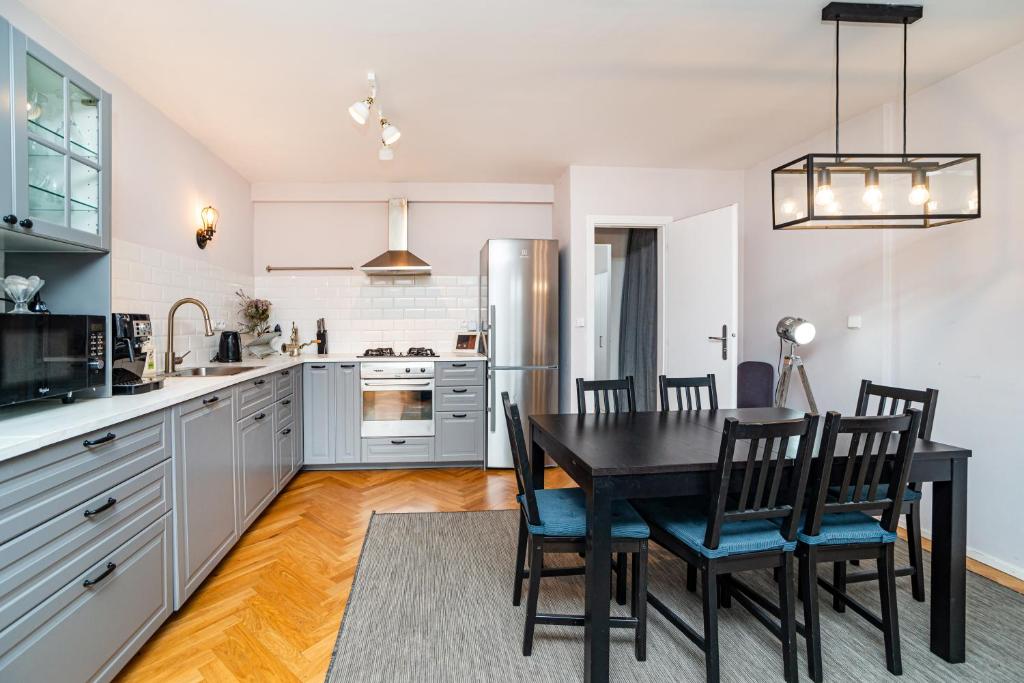 a kitchen with a table and chairs and a refrigerator at Central, Spacious, Modern 5 Bedrm duplex w/Balcony in Prague