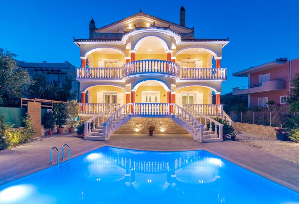 una casa grande con piscina frente a ella en Villa Bella Sole en Kalipádhon