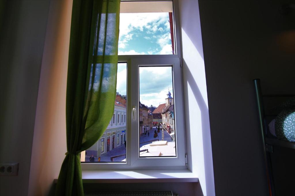 a window with a view of a city at Viva la Vida Hostel in Braşov