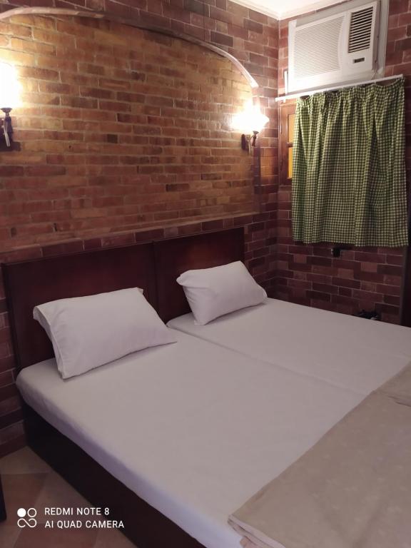 two beds in a room with a brick wall at Studio in Sharm El Sheikh