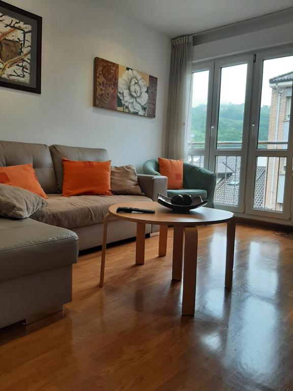 a living room with a couch and a coffee table at Ático La Plaza in Arriondas