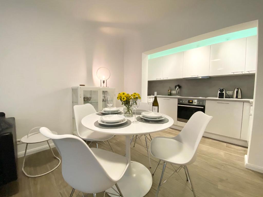 ein weißes Esszimmer mit einem weißen Tisch und Stühlen in der Unterkunft 3-Raum Apartment Quartier57 Hamburg-Eppendorf in Hamburg