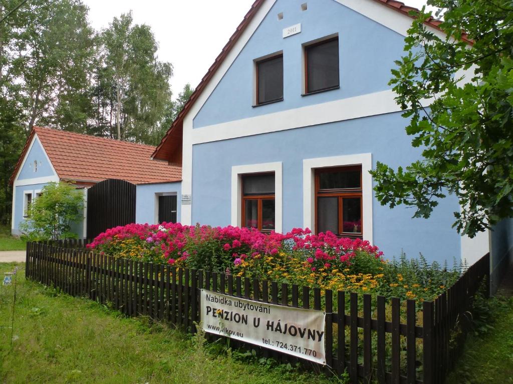 una casa azul con flores delante en Penzion U hájovny u pískoven - Vlkov, en Vlkov