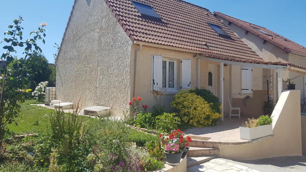 a small house with a garden in front of it at Maison proche de l'aéroport CDG-Paris in Goussainville