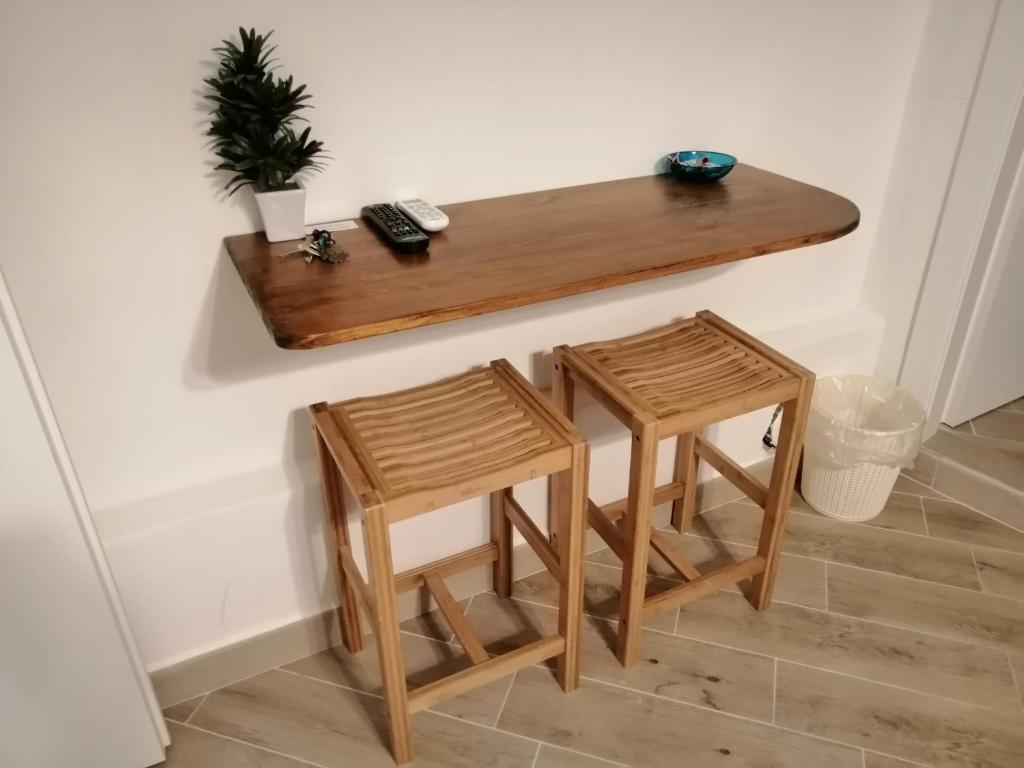 a table and two stools sitting next to a wall at Tre Orologi in Piombino