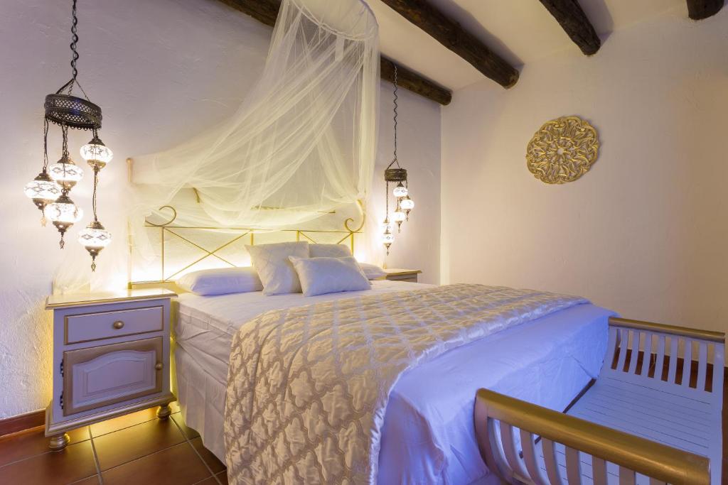 een slaapkamer met een wit bed en een baldakijn bij Carmen Vistas de la Alhambra in Granada