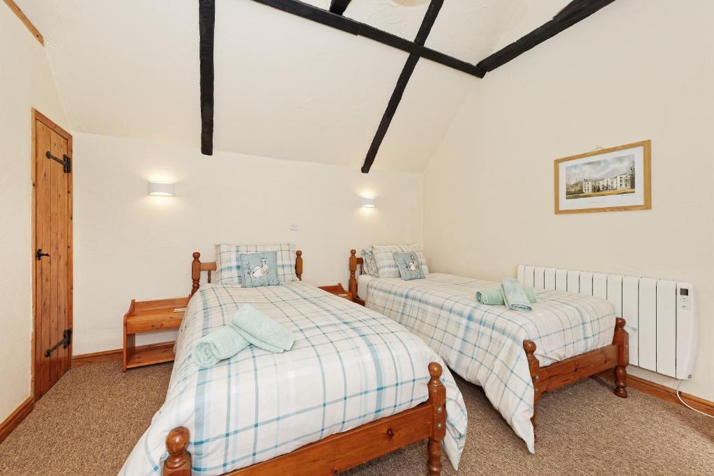two beds in a room with white walls at Beachborough Park in Folkestone
