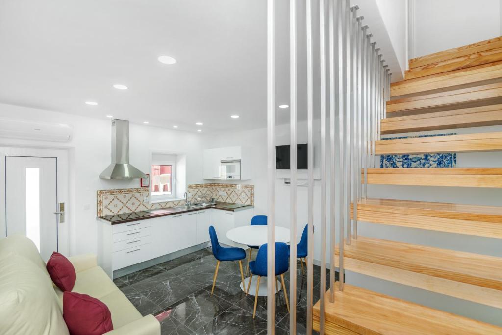 a living room with a staircase and a table and chairs at Maredimo Village Casa 6 in Porto