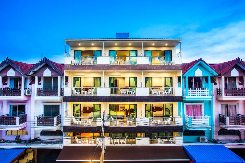 an apartment building with tables and chairs on the balcony at Dream Boutique Hotel in Cha Am