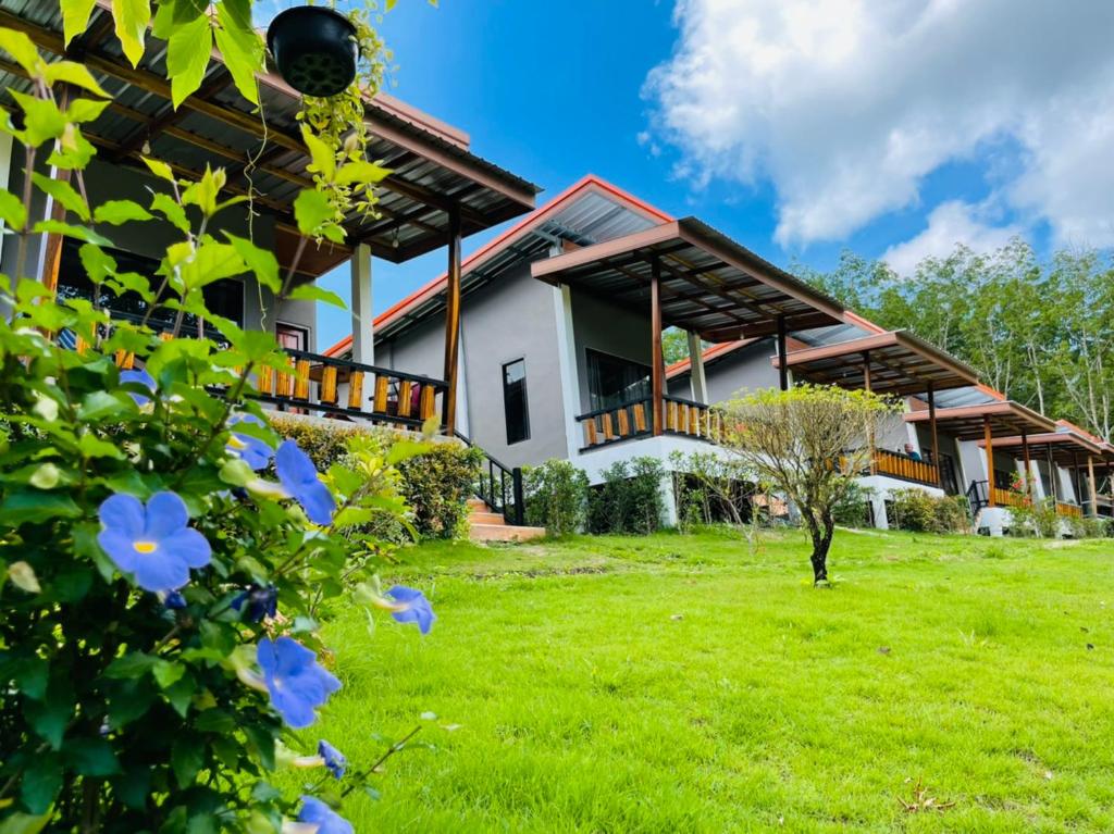 a house with a green lawn in front of it at Phurin Thara Resort in Ko Lanta