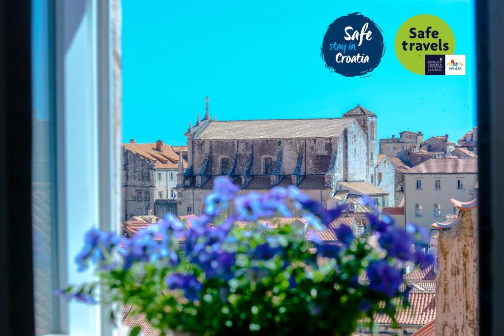 un vaso di fiori viola seduto in una finestra di San Pietro apartment a Dubrovnik