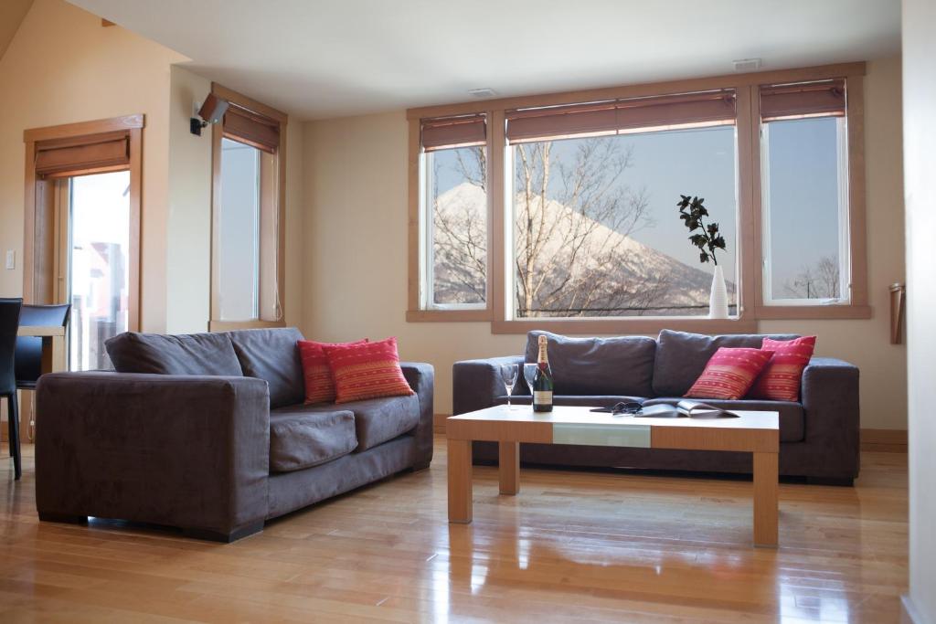 a living room with two couches and a coffee table at Kamakura Apartments in Kutchan