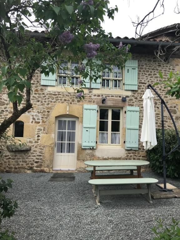 a picnic table in front of a building with blue shutters at Gite Regal in Suaux