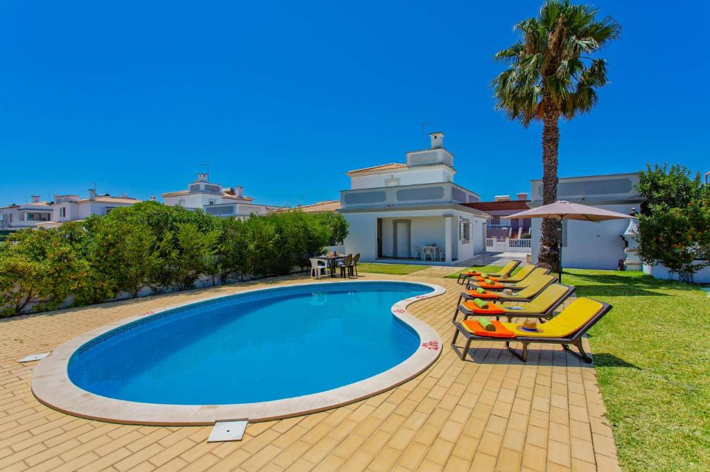 a swimming pool with lounge chairs and a house at Villa Hope by Villa Plus in Galé
